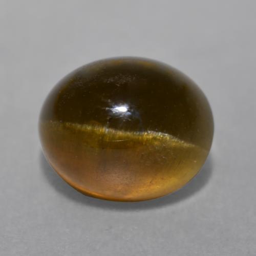 Cat's Eye Apatite طبيعي بلون برتقالي بني عميق، وزن ‎7.22‎ قيراط، شكل بيضاوى، مقاس ‎11.4x9.4‎ مم