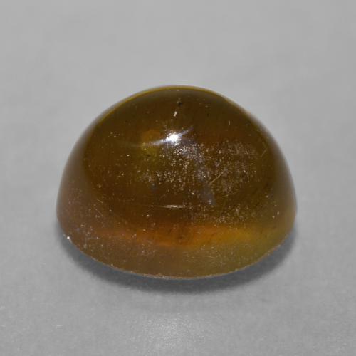 Cat's Eye Apatite طبيعي بلون برتقالي بني عميق، وزن ‎7.22‎ قيراط، شكل بيضاوى، مقاس ‎11.4x9.4‎ مم