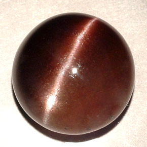 Cat's Eye Scapolite طبيعي بلون بني داكن، وزن ‎11.06‎ قيراط، شكل دائري، مقاس ‎13.87‎ مم