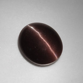 Cat's Eye Scapolite طبيعي بلون بني داكن، وزن ‎5.88‎ قيراط، شكل بيضاوى، مقاس ‎12.9x10.7‎ مم