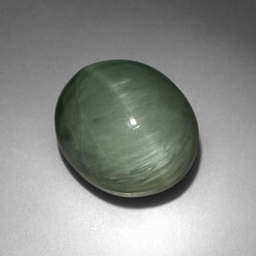 كوارتز عين القط طبيعي بلون أخضر، وزن ‎6.35‎ قيراط، شكل بيضاوى، مقاس ‎12.3x10.5‎ مم