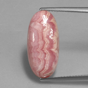 رودوكروسيت طبيعي بلون وردي متعدد الألوان، وزن ‎12.06‎ قيراط، شكل بيضاوى، مقاس ‎19.9x9.5‎ مم