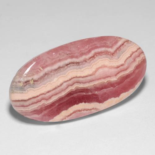 رودوكروسيت طبيعي بلون متعدد الألوان، وزن ‎19.47‎ قيراط، شكل بيضاوى، مقاس ‎26.1x13.1‎ مم