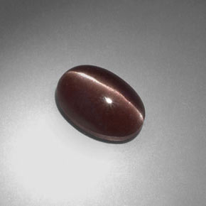 Sillimanite Cat's Eye طبيعي بلون بني أرجواني، وزن ‎2.34‎ قيراط، شكل بيضاوى، مقاس ‎10.1x6.9‎ مم