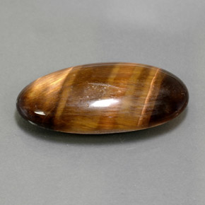 Tiger's Eye طبيعي بلون بني ذهبي، وزن ‎13.84‎ قيراط، شكل بيضاوى، مقاس ‎25.4x13‎ مم