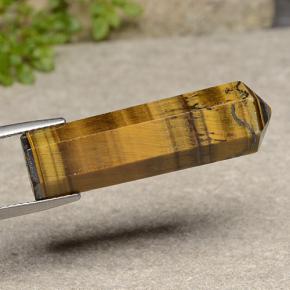 Tiger's Eye طبيعي بلون بني فاتح، وزن ‎24.72‎ قيراط، شكل شكل خيالي، مقاس ‎33.1x9.5‎ مم